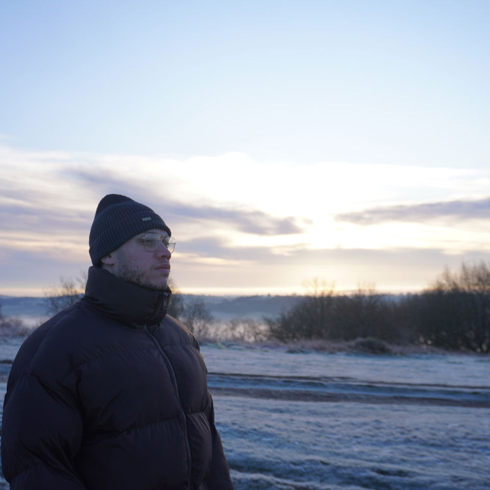 Model looking out at a scenic icey hills reflecting on life.